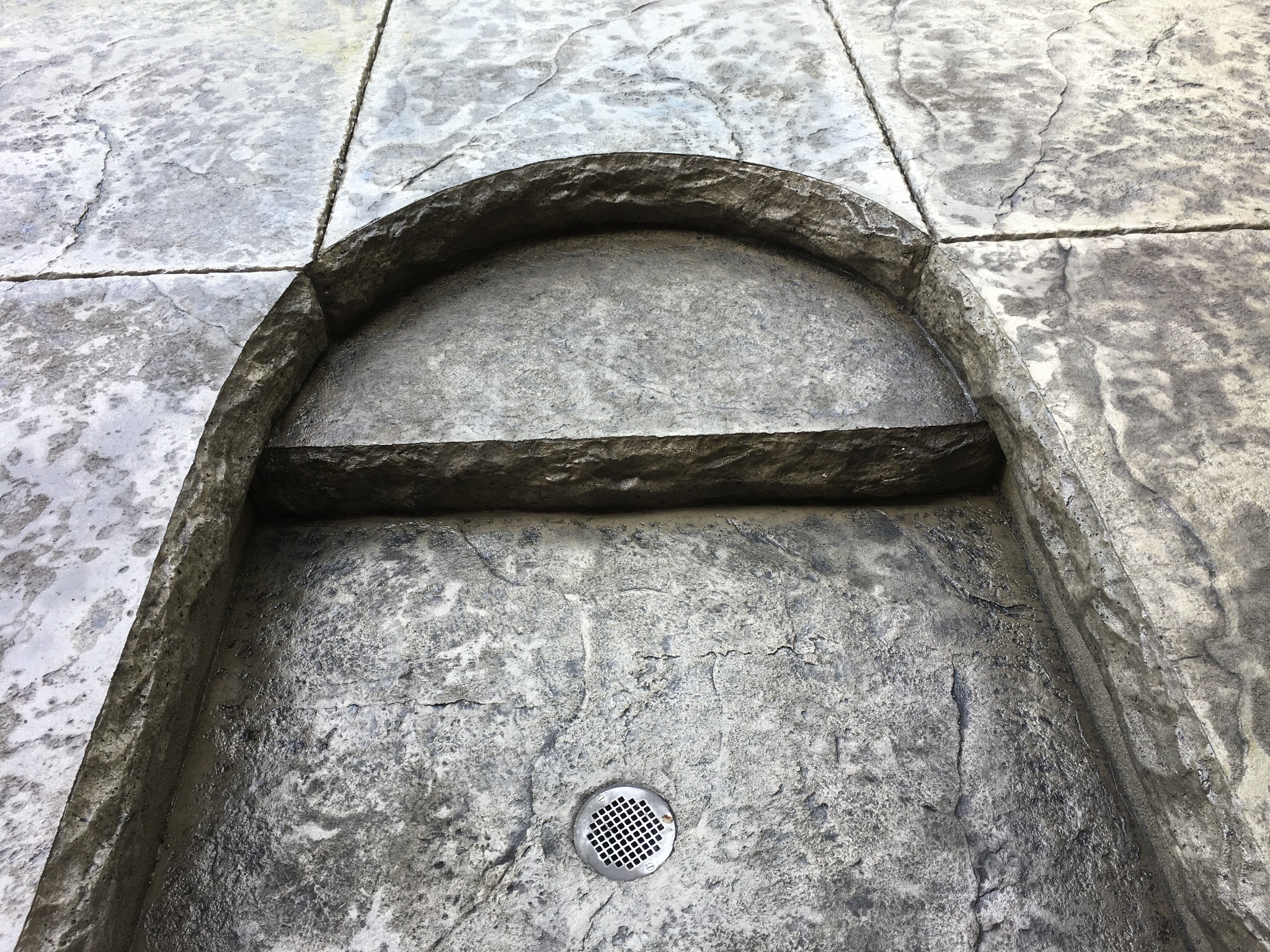 Pool deck with gates, stamped concrete, and water features