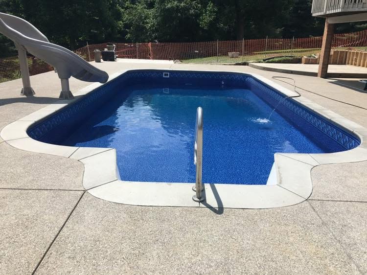 Pool with slide and spacious concrete surround